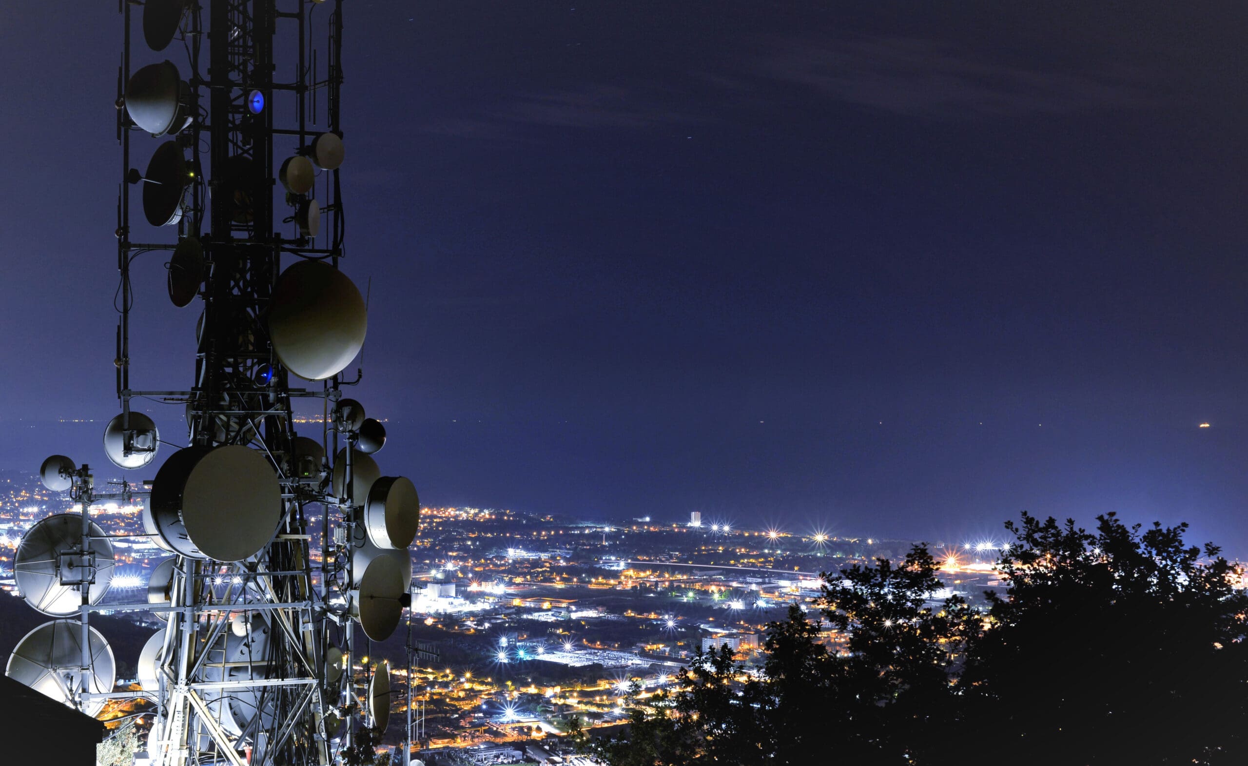 Telecommunications,Tower,,Antenna,And,Satellite,Dish,And,City,At,Night